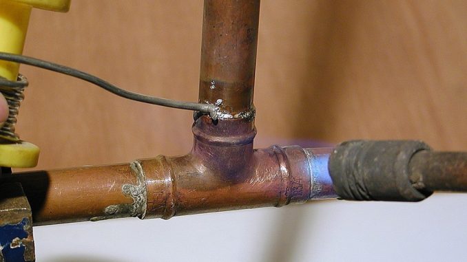 Copper pipe repair being carried out in a domestic setting