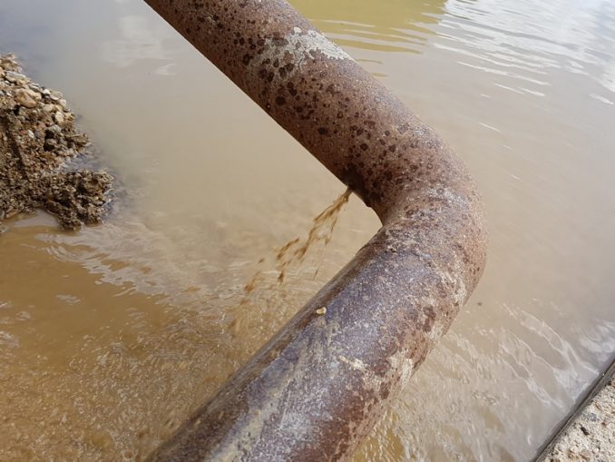 A leaking steel pipe elbow bend at a quarry in the UK before being fixed with a SylWrap Standard Pipe Repair Kit